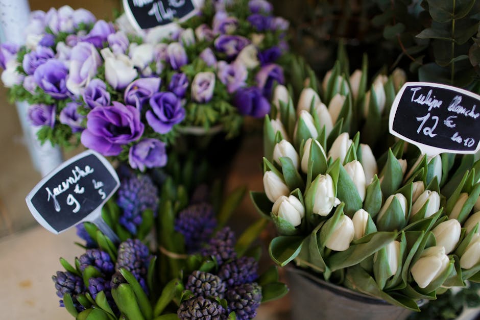 A close-up view of a floral display at earlsfieldflorist.co.uk featuring two bouquets of fresh flowers. On the left, there's a bouquet of purple and white eustoma (lisianthus) flowers with ruffled pet