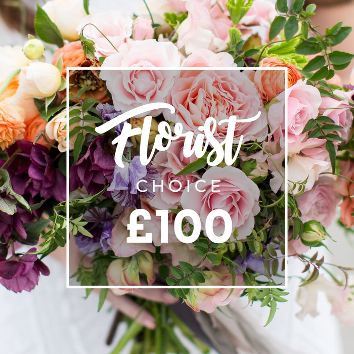 A generous, hand-tied bouquet fills the frame in lush detail, a proud example of florist-crafted artistry from Earlsfield Florist. Pale pink garden roses, full and velvety with many ruffled layers, form the bouquet's heart; intermingled are delicate white accent blooms and pale purple-and-white sweet peas whose fragile, fluted petals float above the greenery. Deeper plum or burgundy hellebore-like flowers cluster lower in the composition, providing a dramatic counterpoint to the pastels, while peach and coral ranunculus-style blossoms add soft warmth and visual rhythm. The arrangement is enriched by an abundance of foliage - narrow, trailing vines, broad matte leaves and eucalyptus-like stems - which together create a natural, garden-style silhouette and a gentle herbal fragrance beneath the floral notes. A thin white rectangular frame overlays the centre with elegant script reading Florist Choice, a smaller block CHOICE beneath it, and a bold ?100 at the bottom, clearly signalling this is a bespoke, florist-selected option at a stated price. A person's hands cradle the bouquet at the base of neatly trimmed stems; a faint white sleeve and blurred neutral clothing in the background suggest careful, human presentation. Soft daylight reveals fine petal texture and the subtle sheen on each bloom, inviting the sense of scent and touch. Photographed to emphasise quality and seasonal selection, this bouquet is pitched as a luxurious, heartfelt gift for weddings, anniversaries, or to comfort and celebrate - available for careful hand-delivery across Earlsfield, near Garratt Lane and the Wandle Park area.